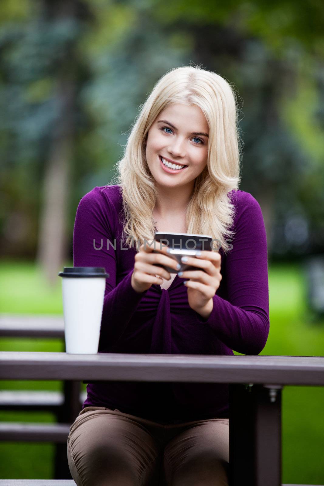Portrait of Young Woman with Cell Phone by leaf