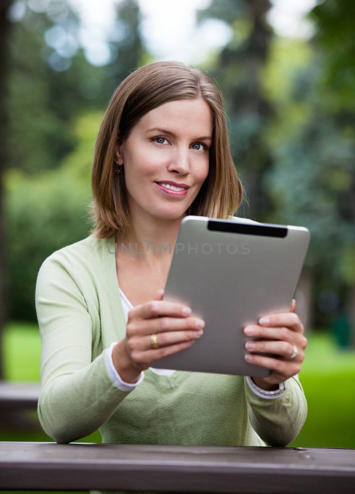 Woman in Park with Digital Tablet by leaf