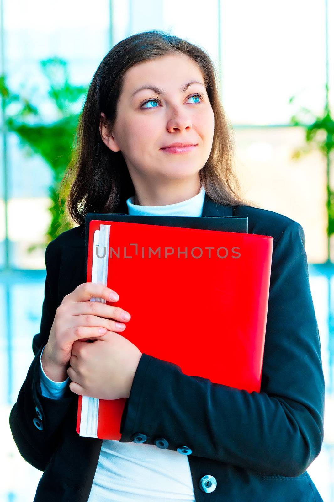 Encouraged by a businesswoman holding a red folder with documents on background of office interior by kosmsos111