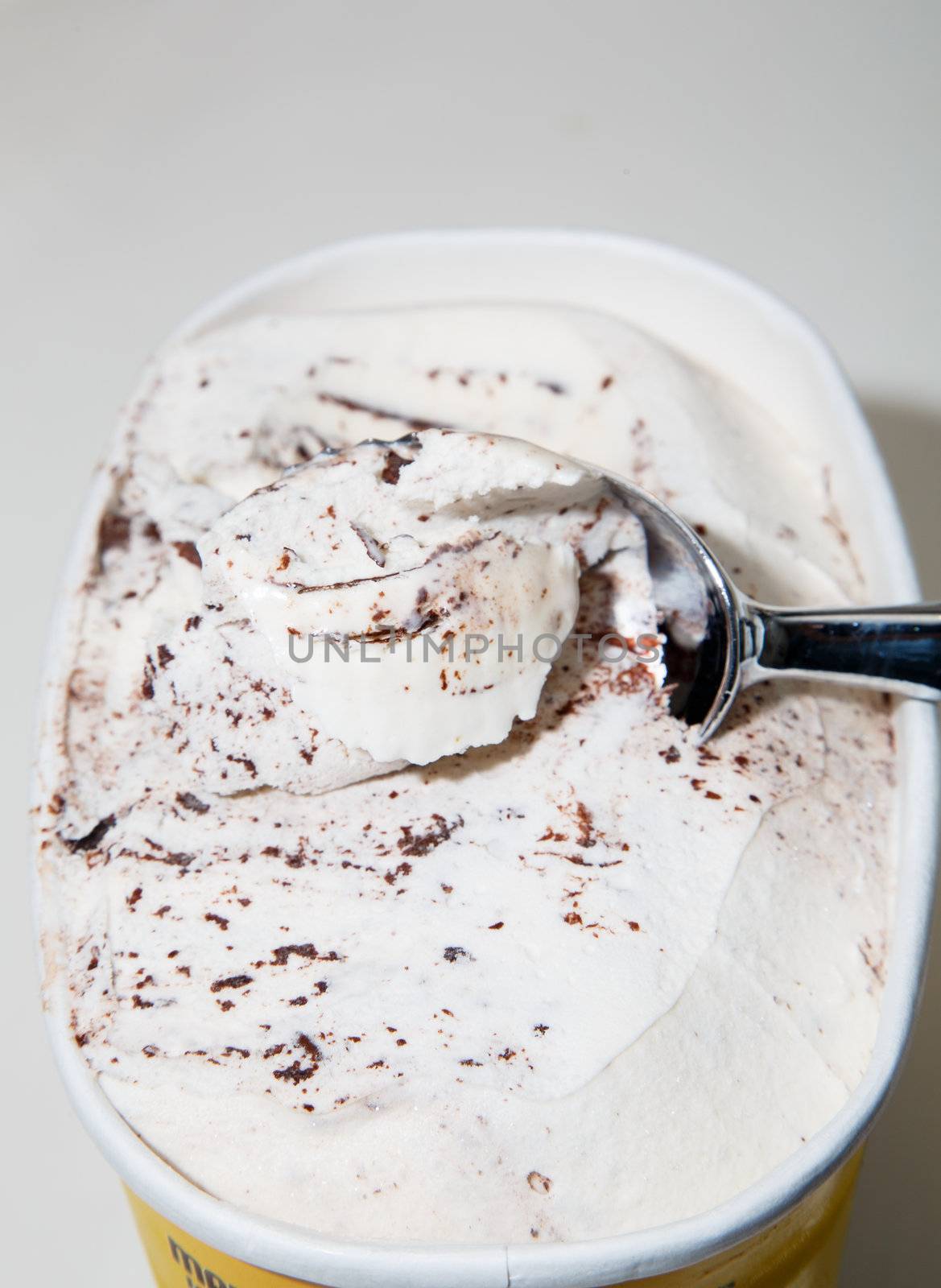 Carton of chocolate chip ice cream with ice cream scoop