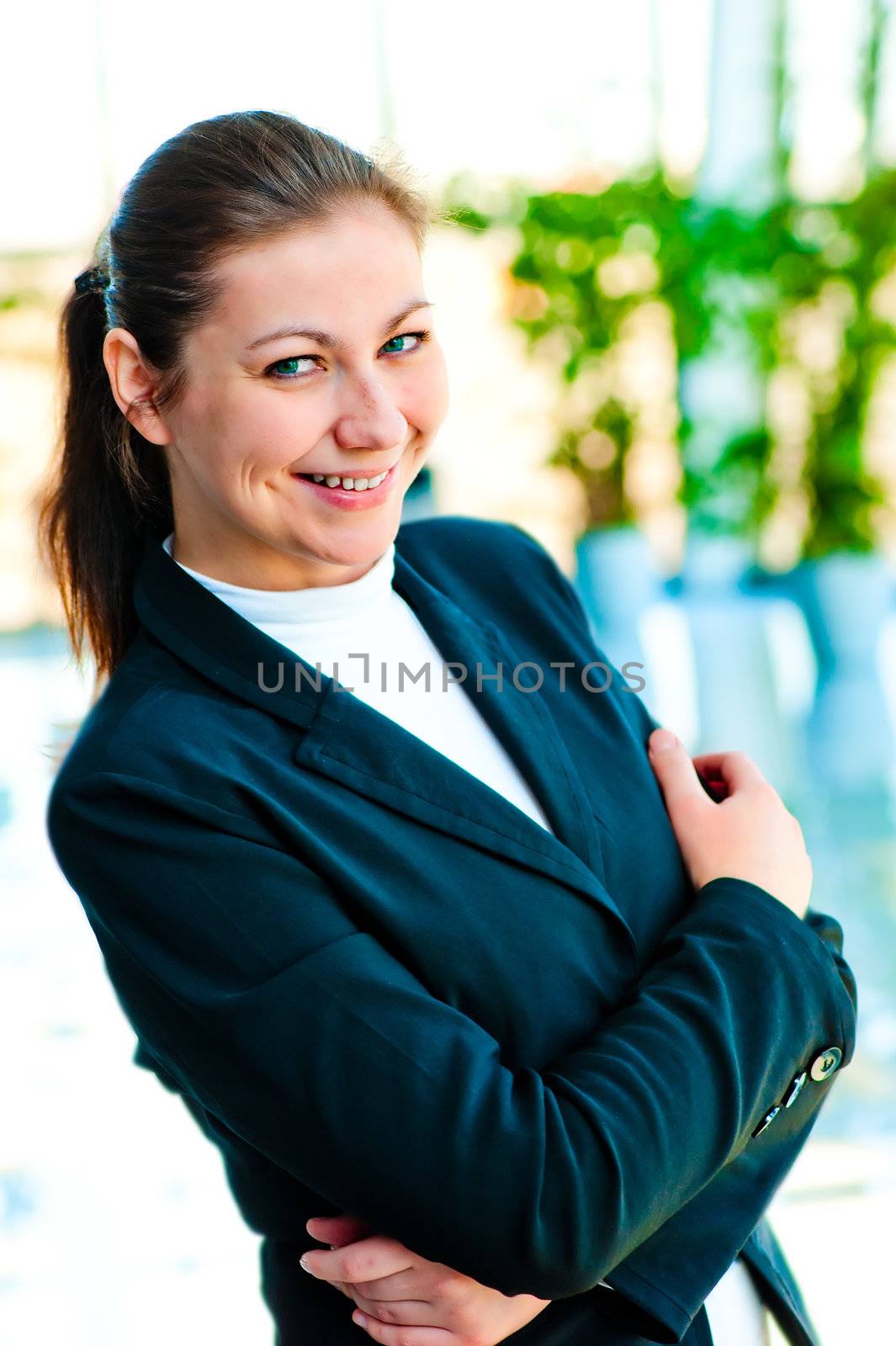 Portrait of successful business woman smiling on the background of a blurred office interior by kosmsos111