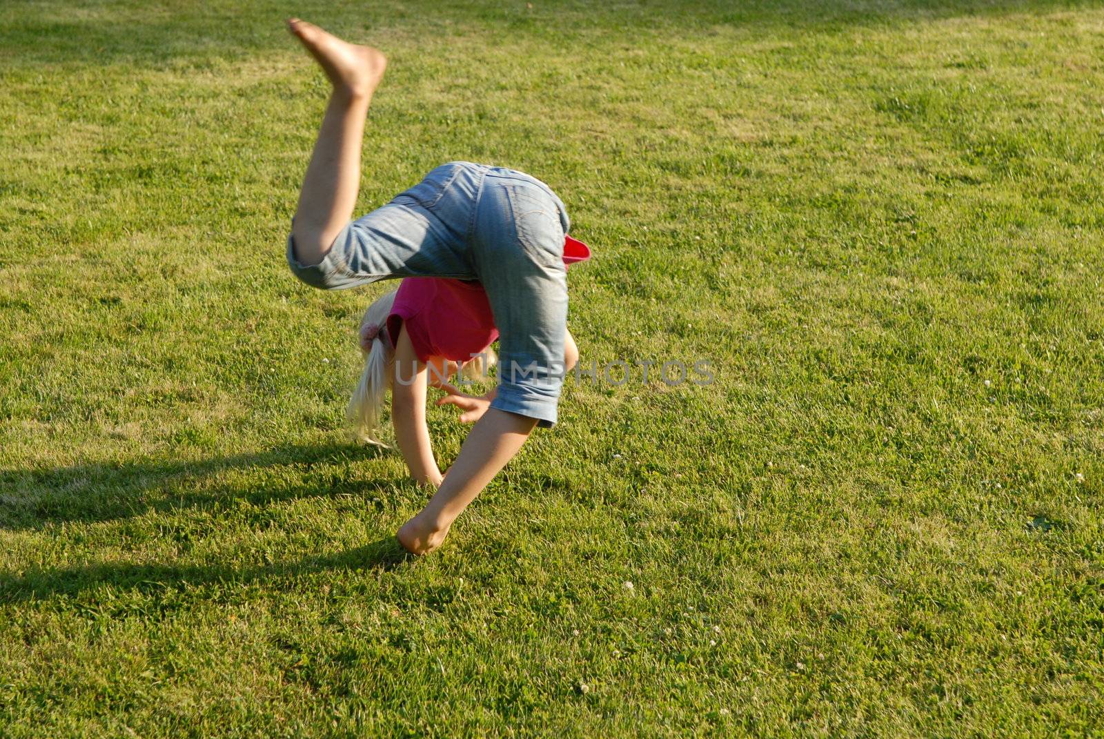 Scandinavian Lifestyle-Girl doing gymnastics in the garden by Bildehagen