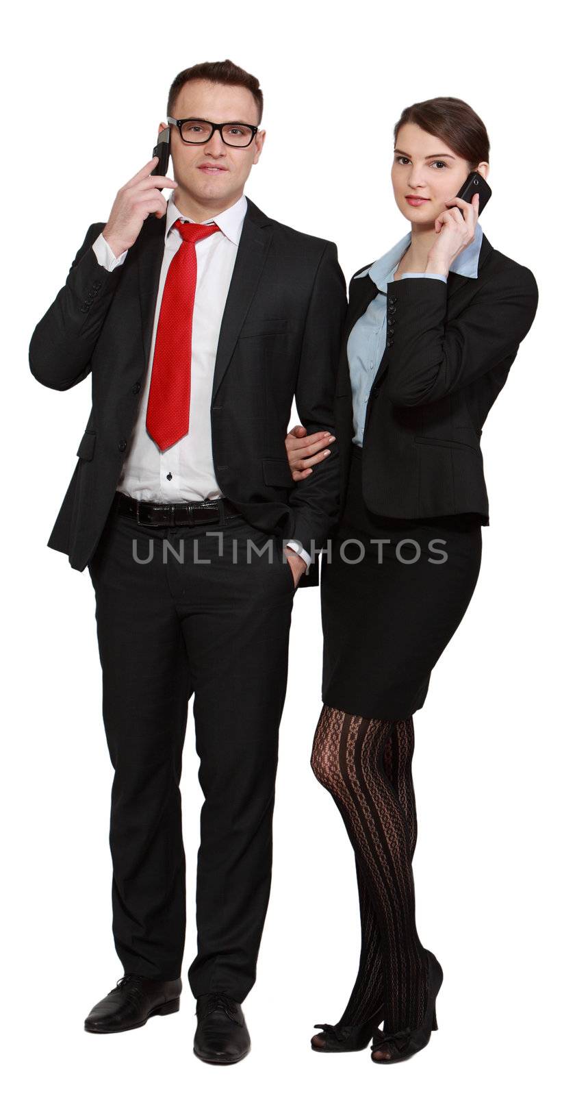 Young business couple using mobile phones isolated against a white background.
