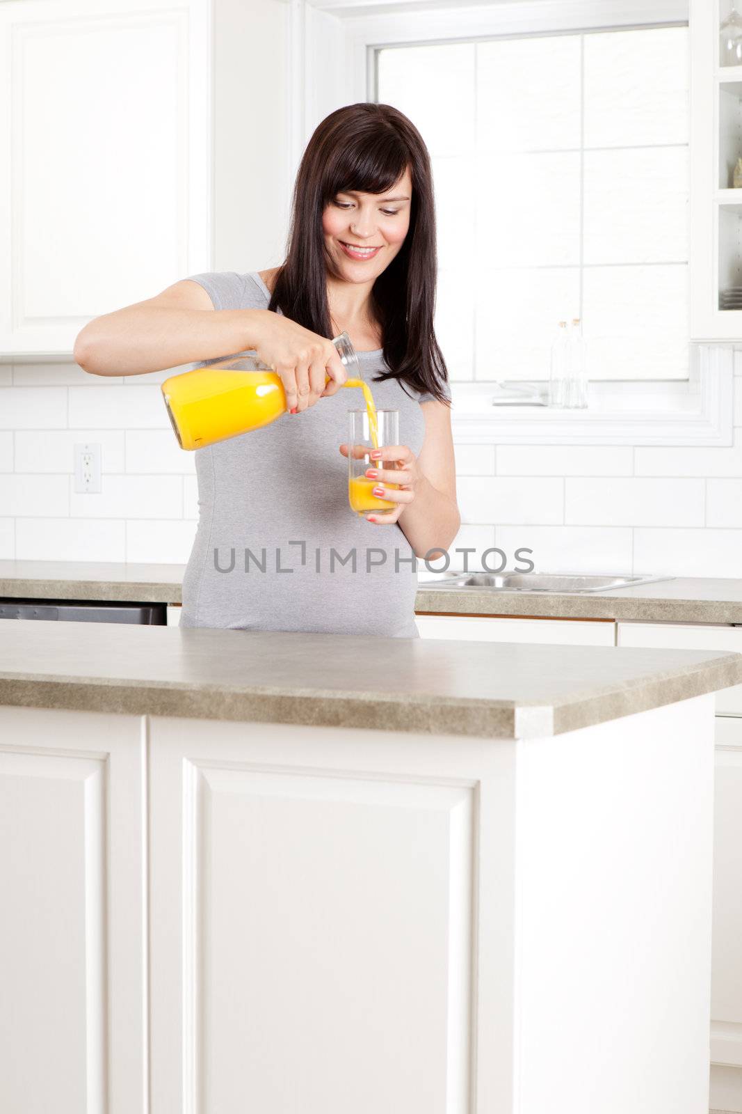 Pregnant Woman pouring Orange Juice by leaf