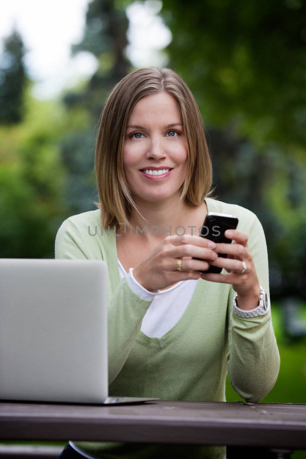 Attractive Woman in Park with Smart Phone by leaf