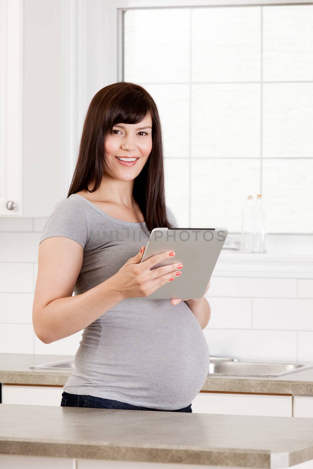 Pregnant Woman with Digital Tablet by leaf