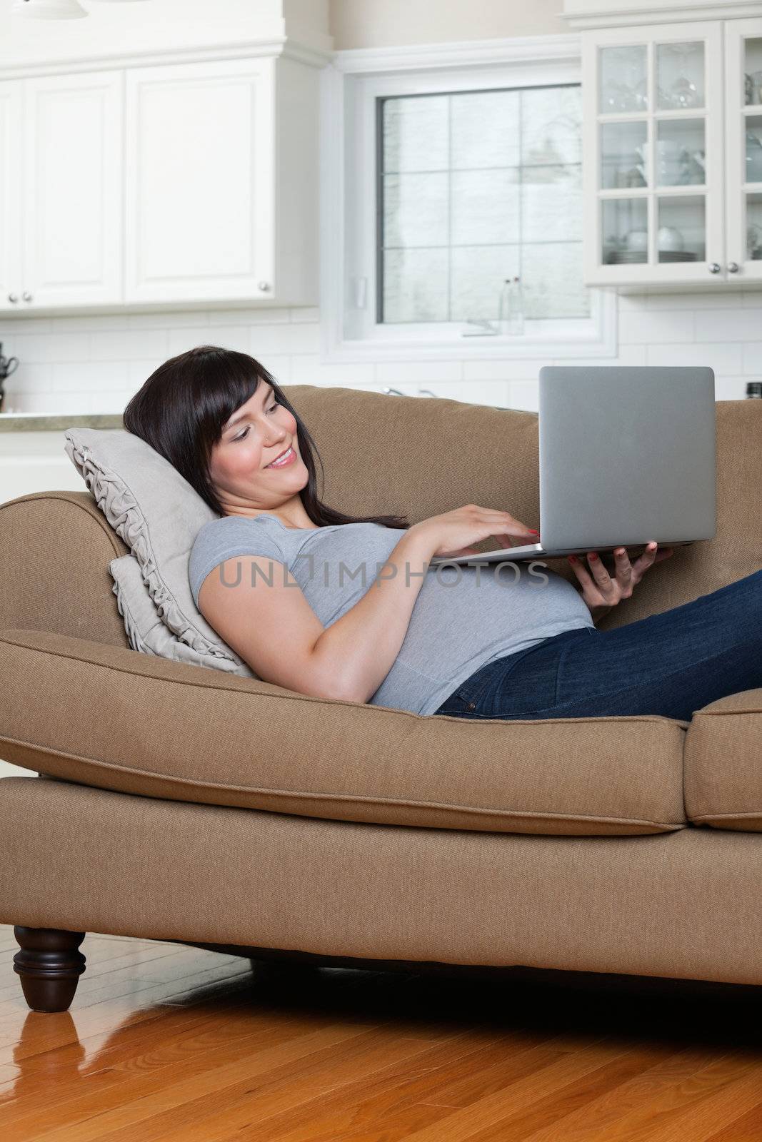 Relaxed Pregnant Woman Using Laptop by leaf