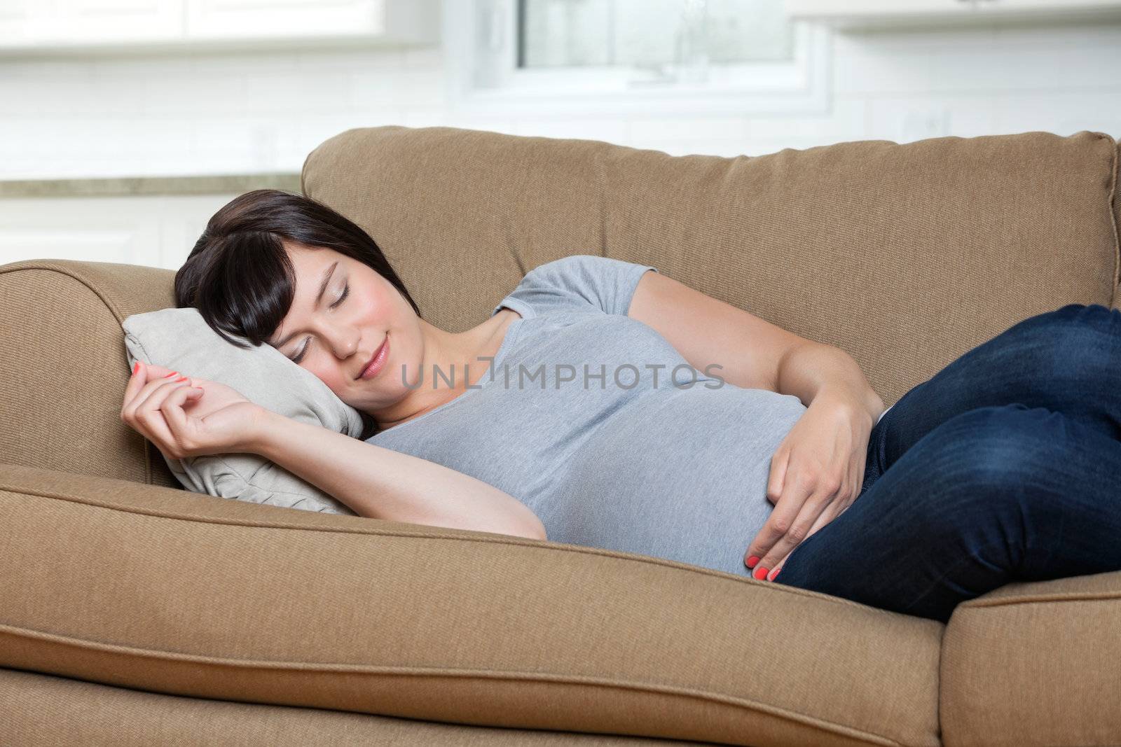 Pregnant woman sleeping on sofa at home