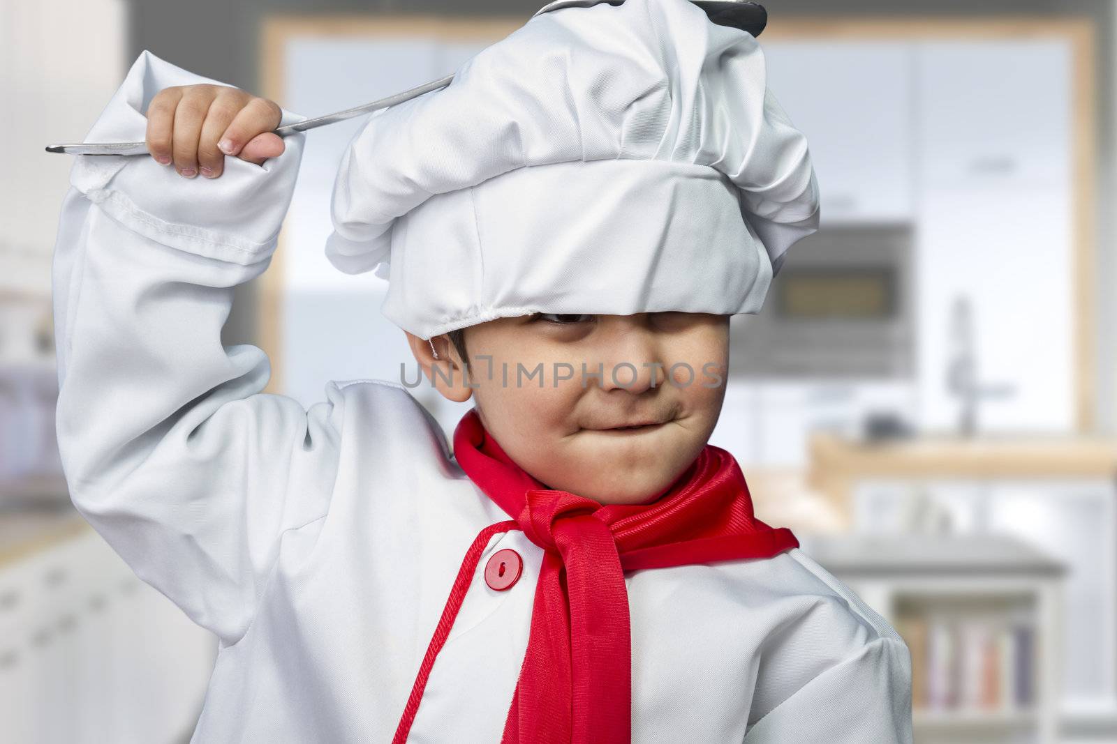 funny child dressed as a cook with a pan hitting the head