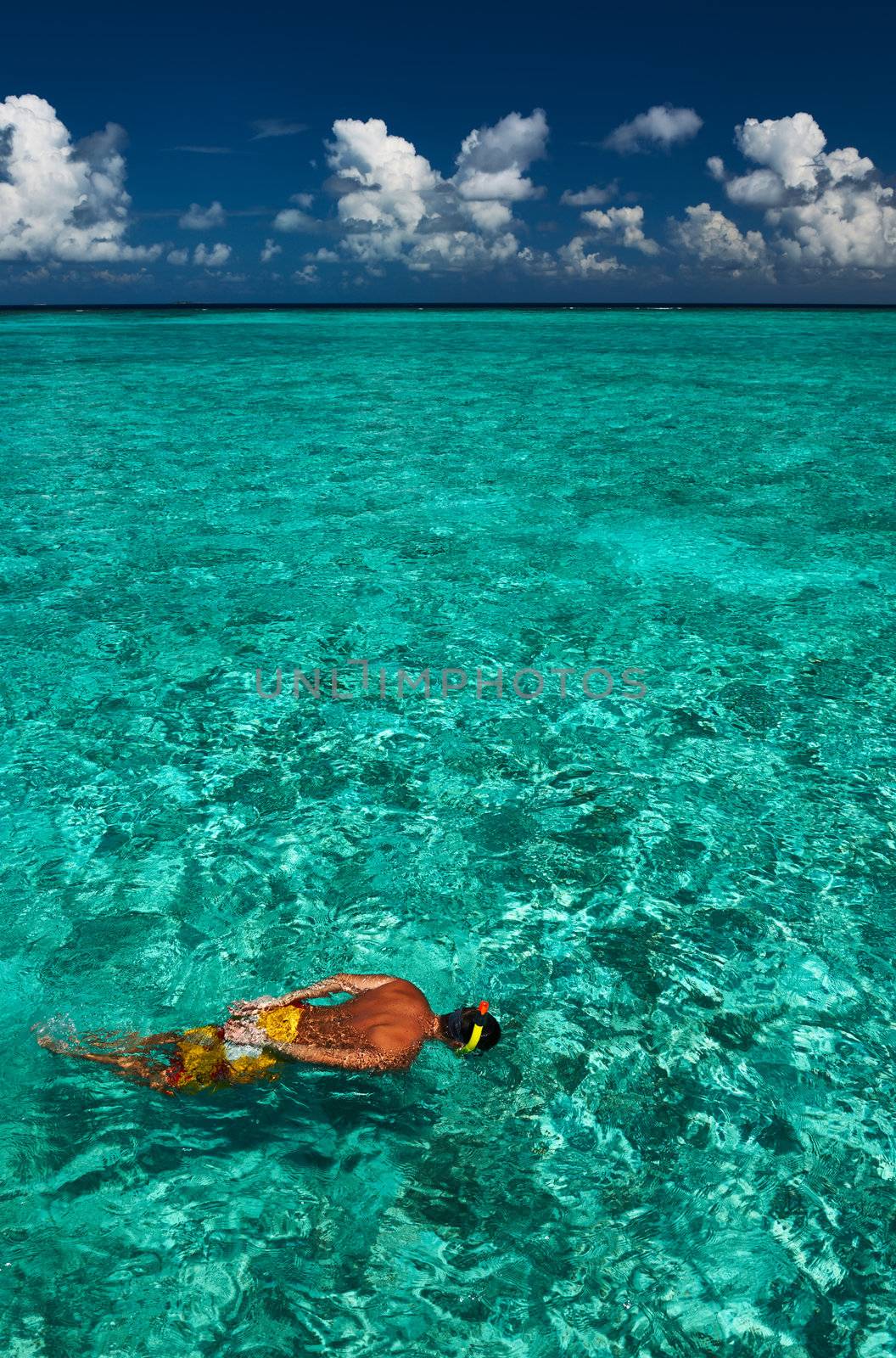 Man snorkeling in crystal clear turquoise water at tropical beach