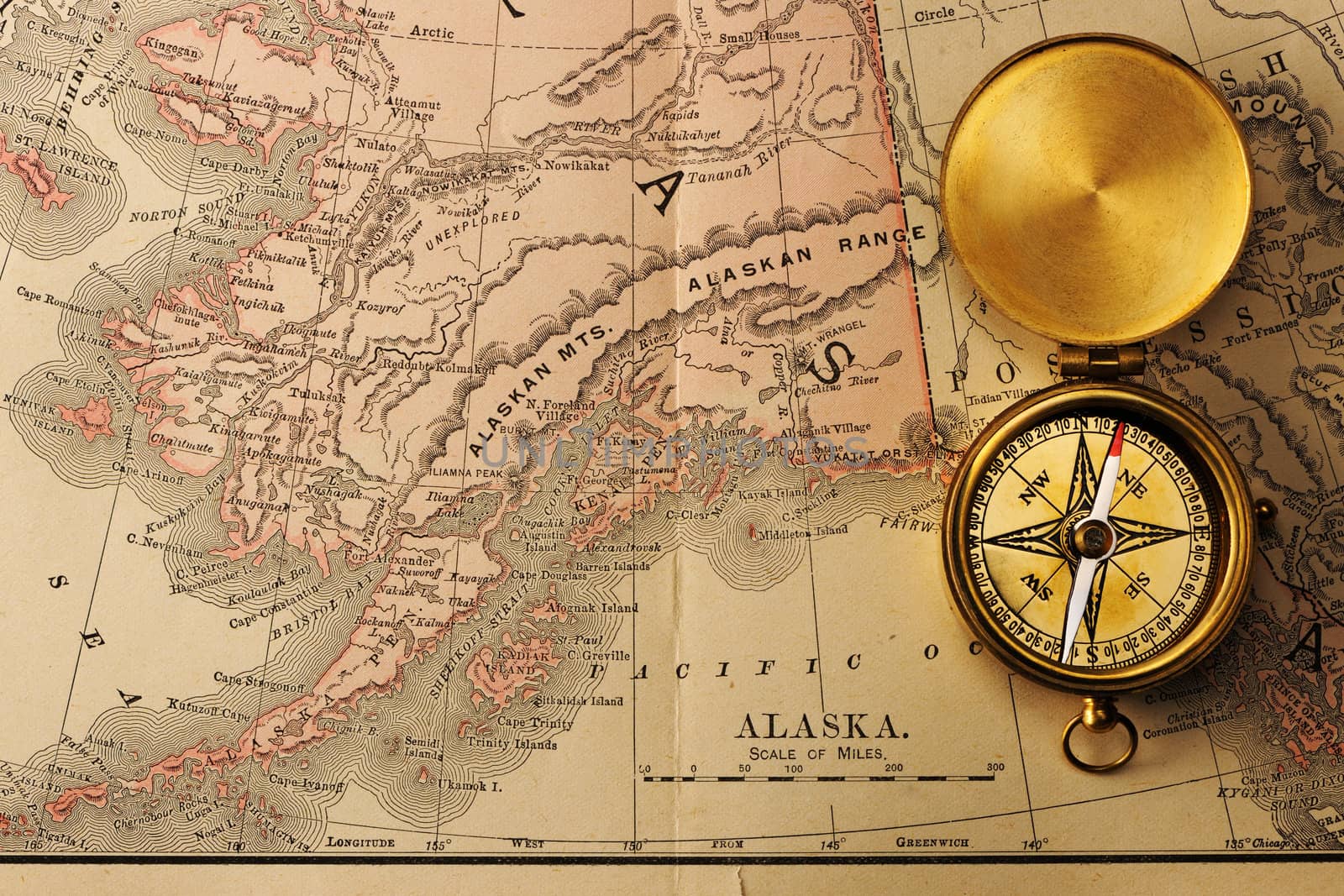 Antique brass compass over old XIX century map