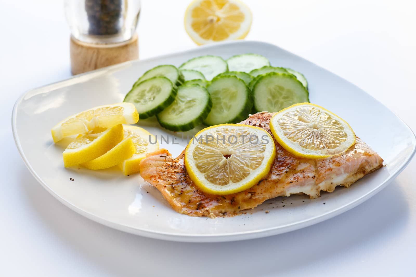 Baked salmon with lemon slices and cucumbers