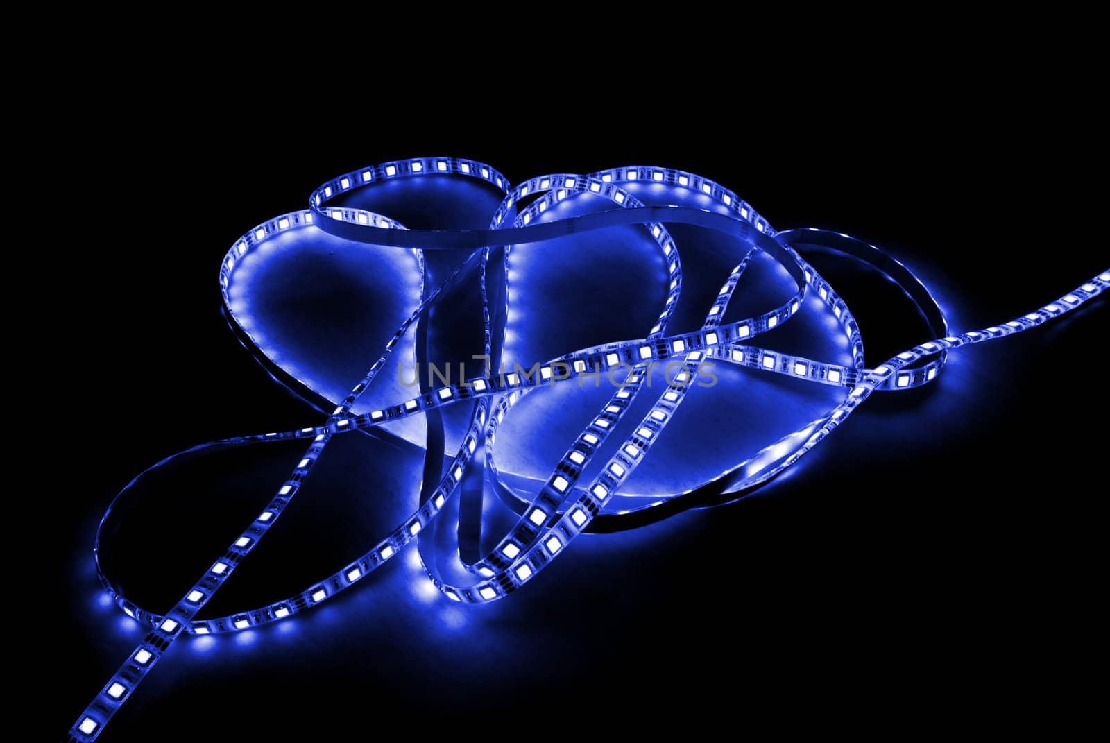 blue led strip with a glue layer, background in the dark, illuminated by strip