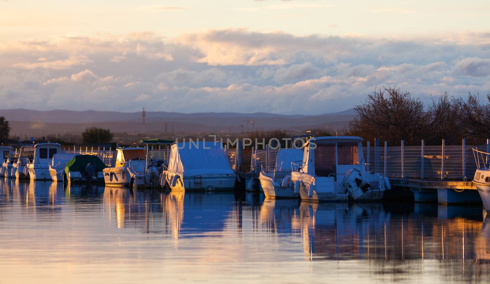 Boats in a marina at sunset by Discovod