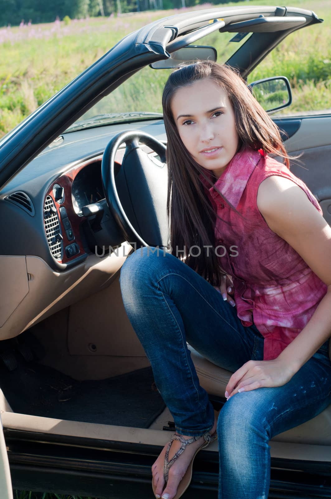 Beautiful brunette woman sitting in the car by anytka