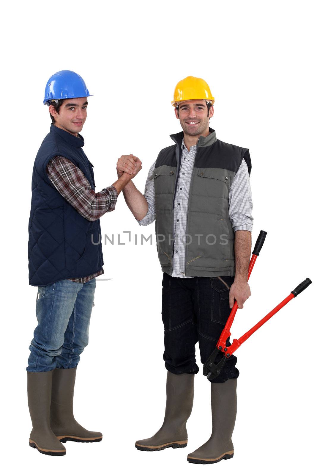 Two manual workers shaking hands by phovoir