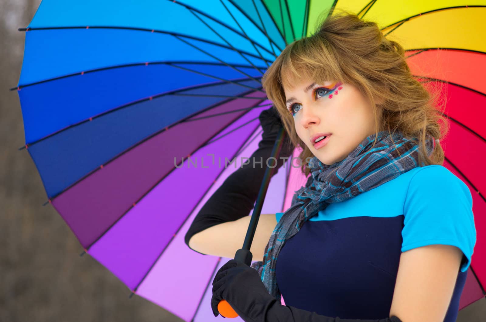 Young woman with multicolor umbrella at winter forest