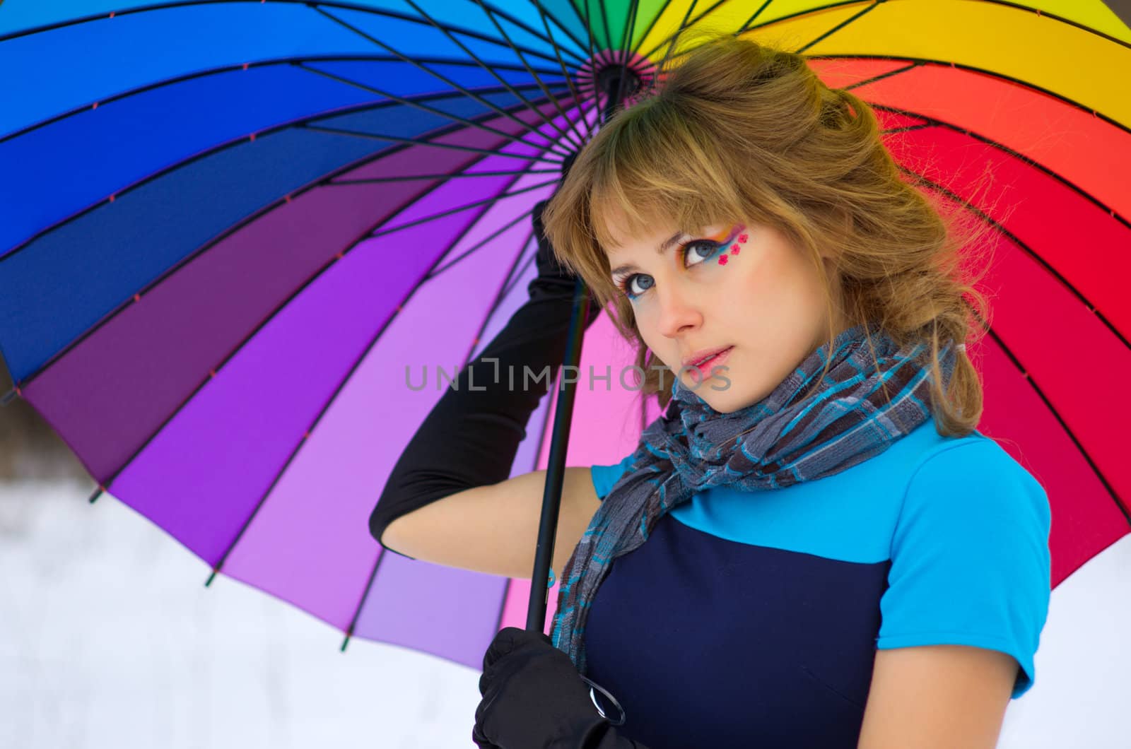 Young woman with multicolor umbrella at winter forest