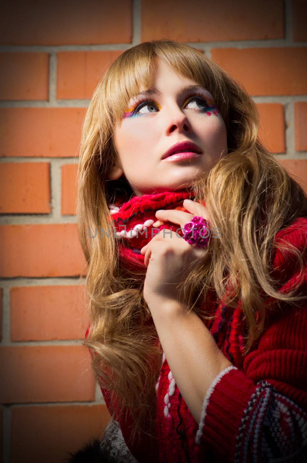 Fashion portrait of young woman on brick wall background