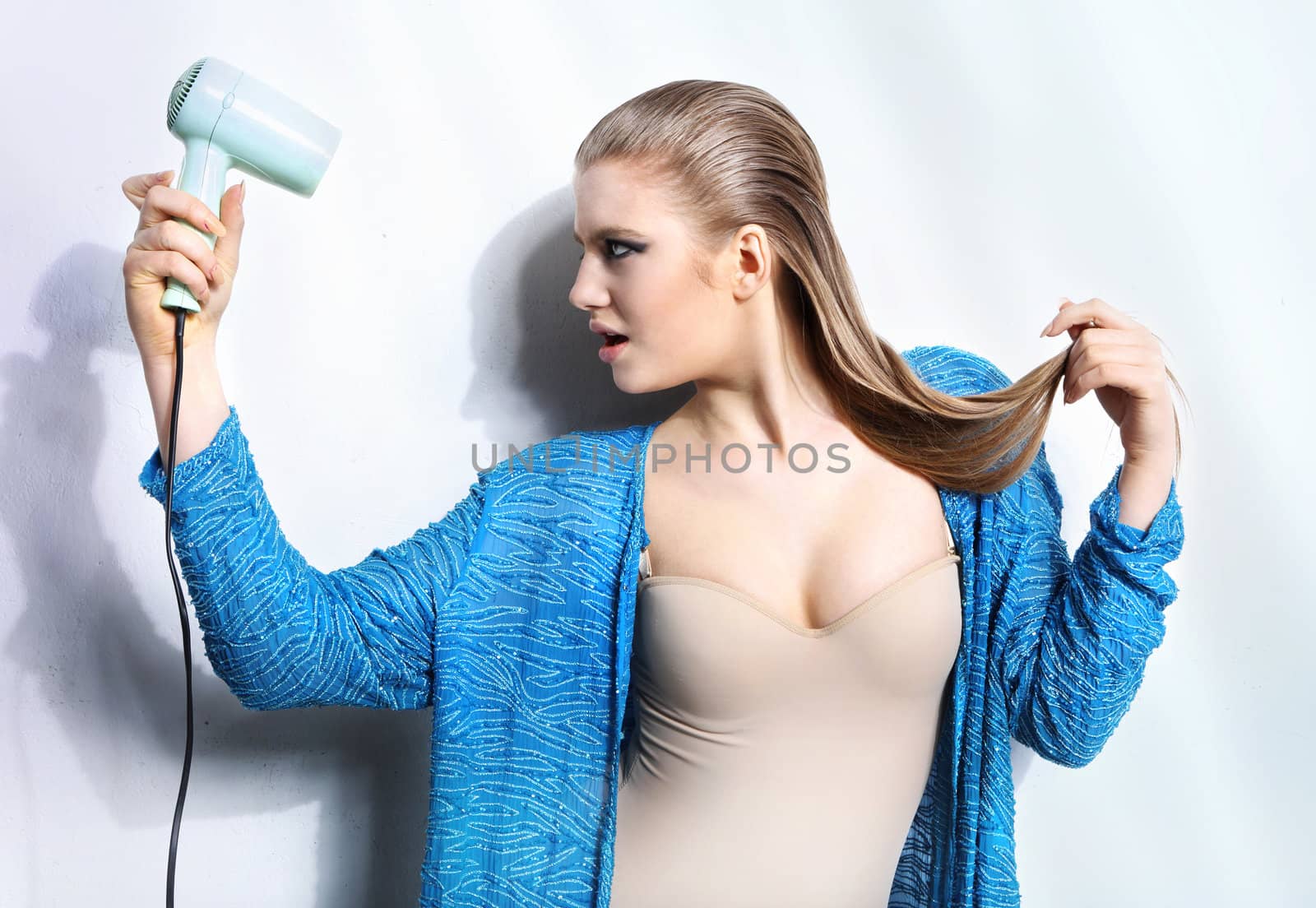 Portrait of beautiful woman holding hair dryer by robert_przybysz