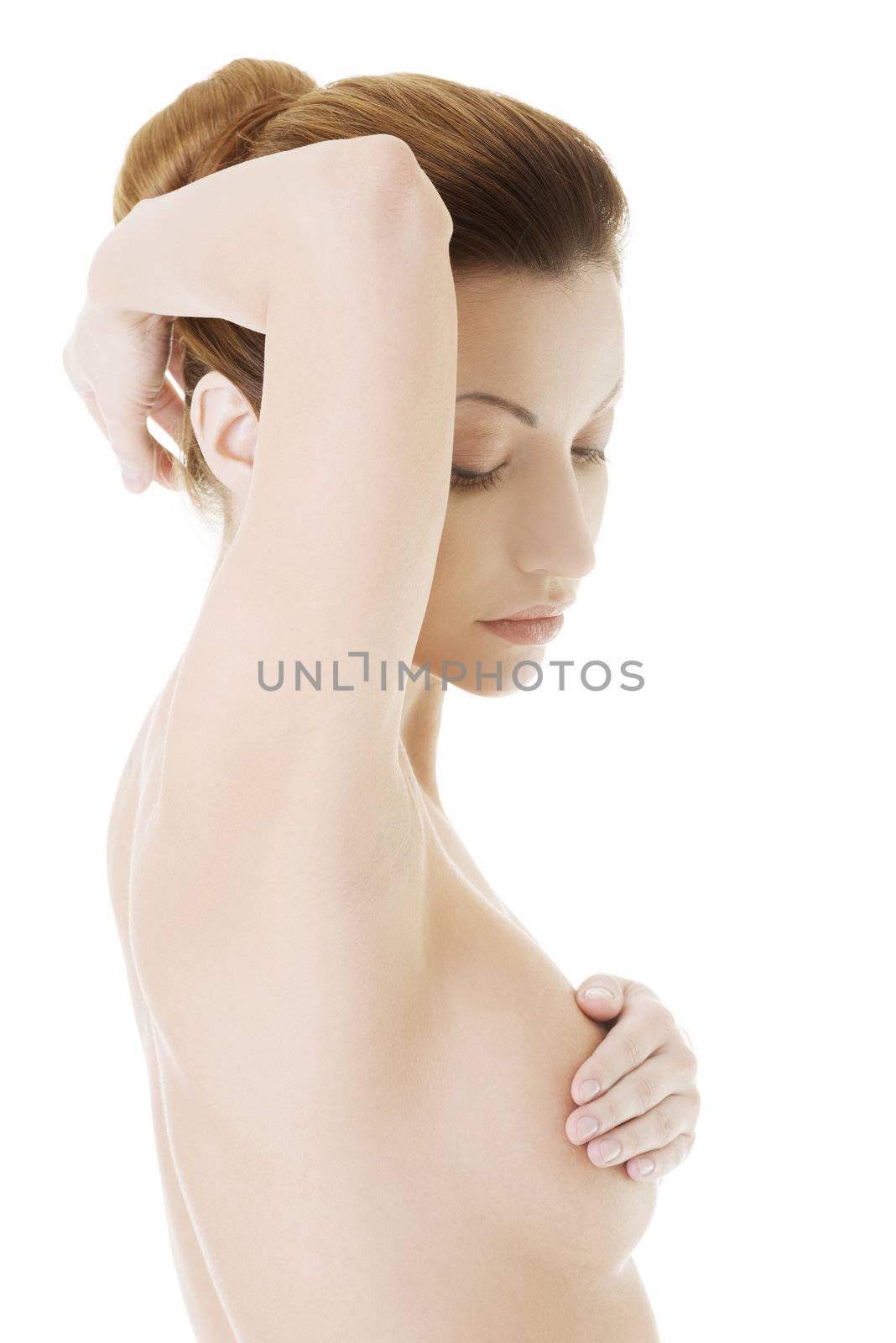 Caucasian adult woman examining her breast for lumps or signs of breast cancer