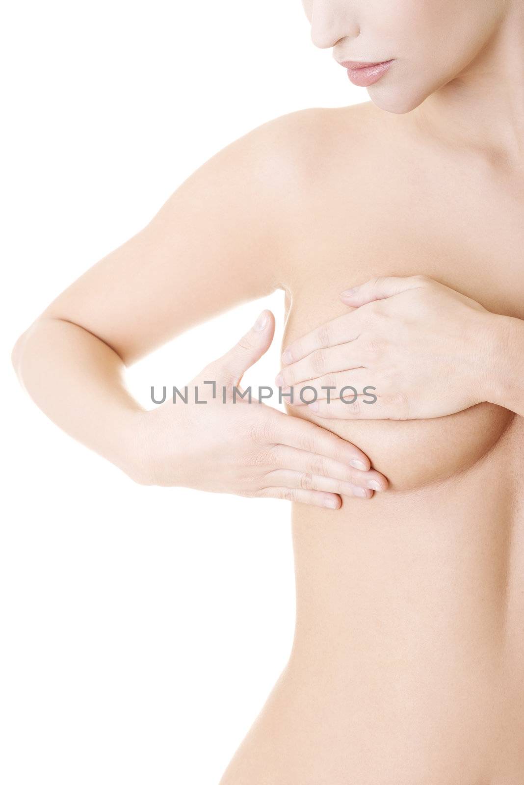 Caucasian adult woman examining her breast for lumps or signs of breast cancer