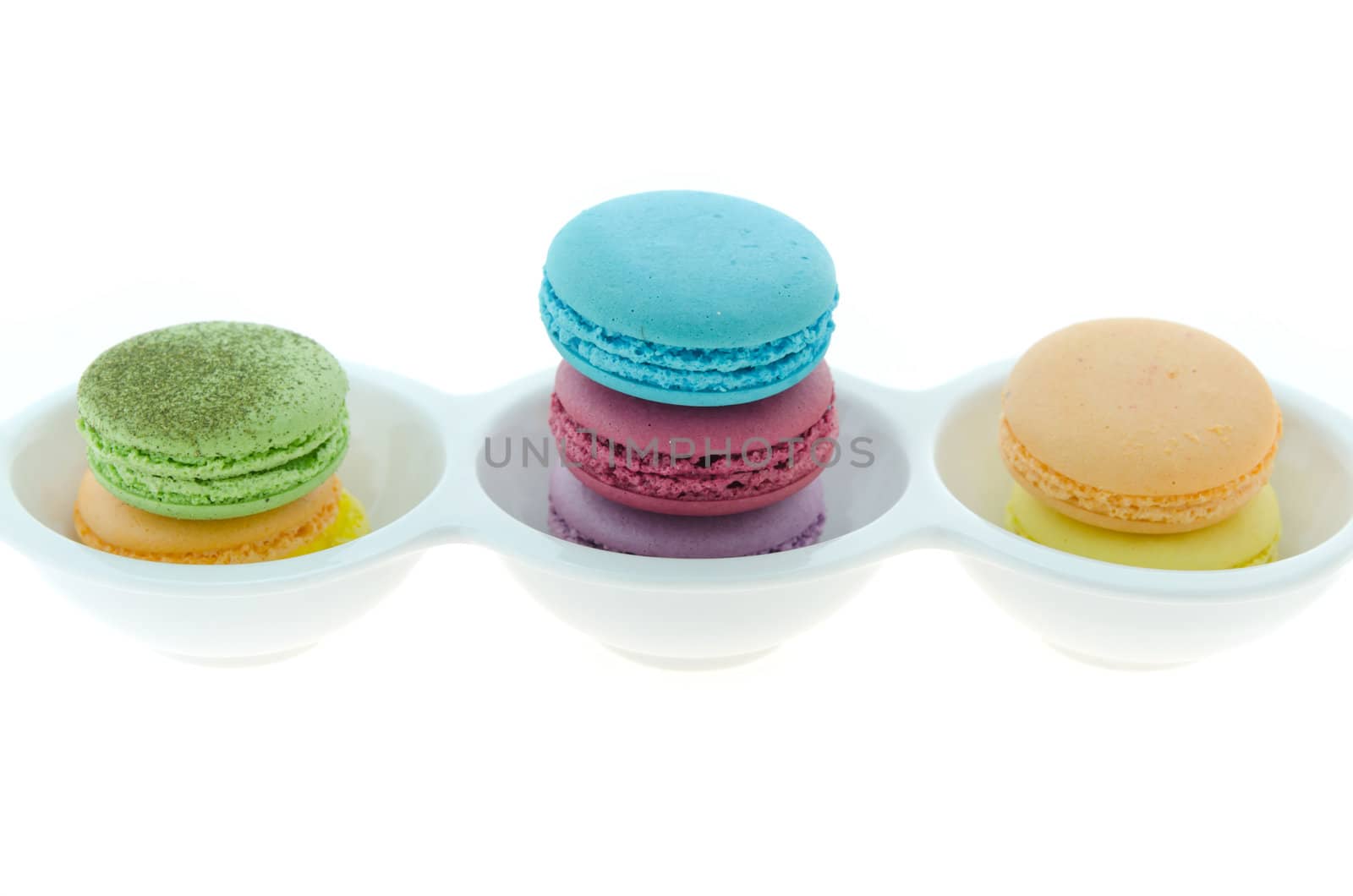 colorful of French macaroons stack  in bowl over white background