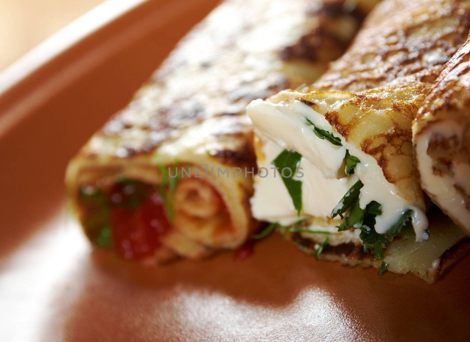 rolled pancakes stuffed ham and cheese. Shallow depth-of-field.