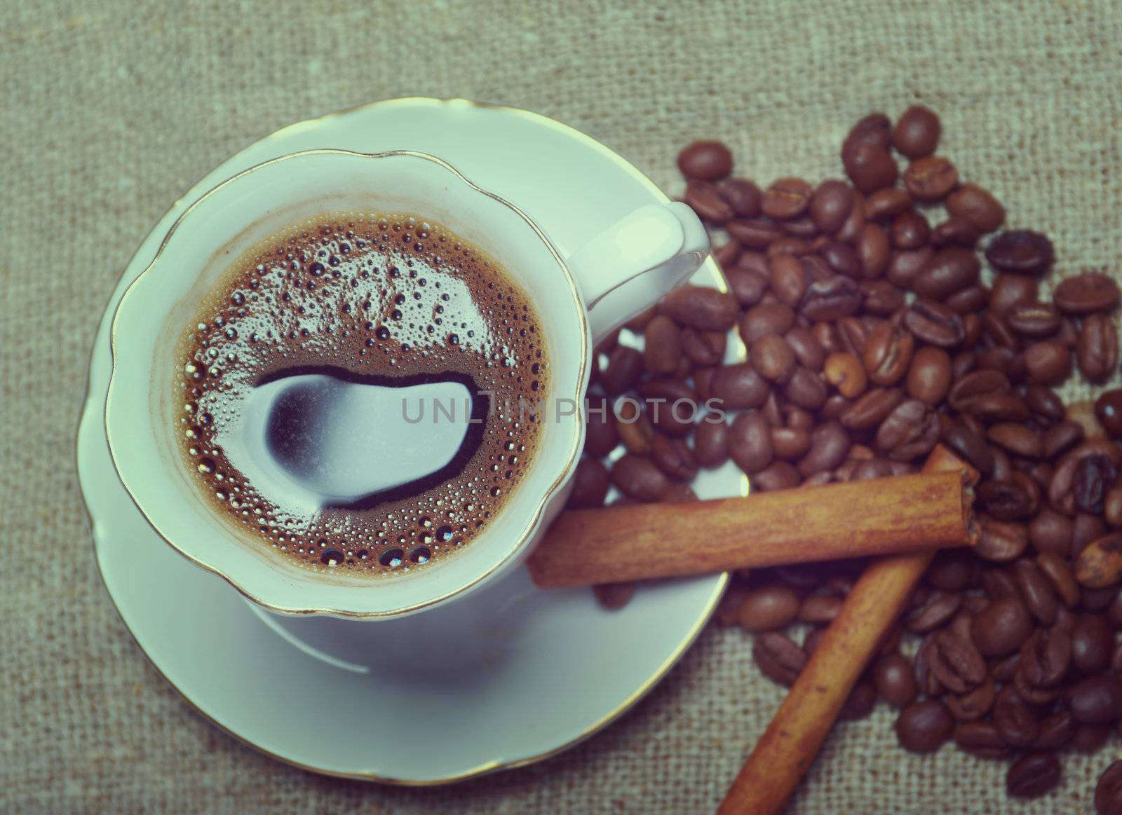 Coffee cup with cinnamon and coffee beans background