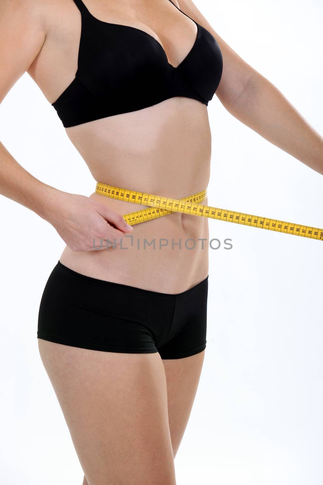 Woman holding a tape measure round her waist by phovoir