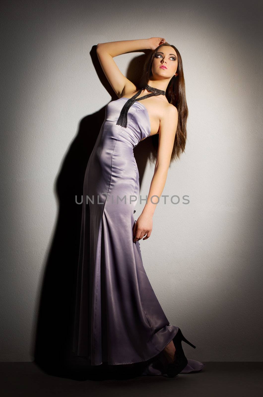 Fashion portrait of young woman about a wall