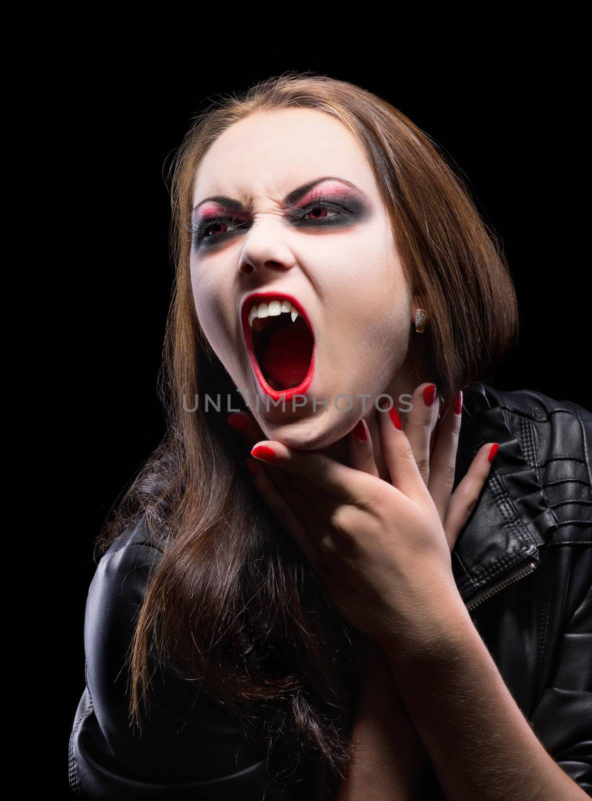 Young vampire girl isolated on black