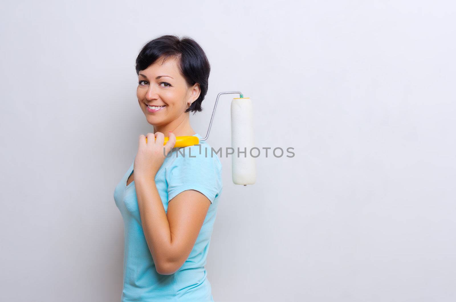 Smiling woman with painting roller