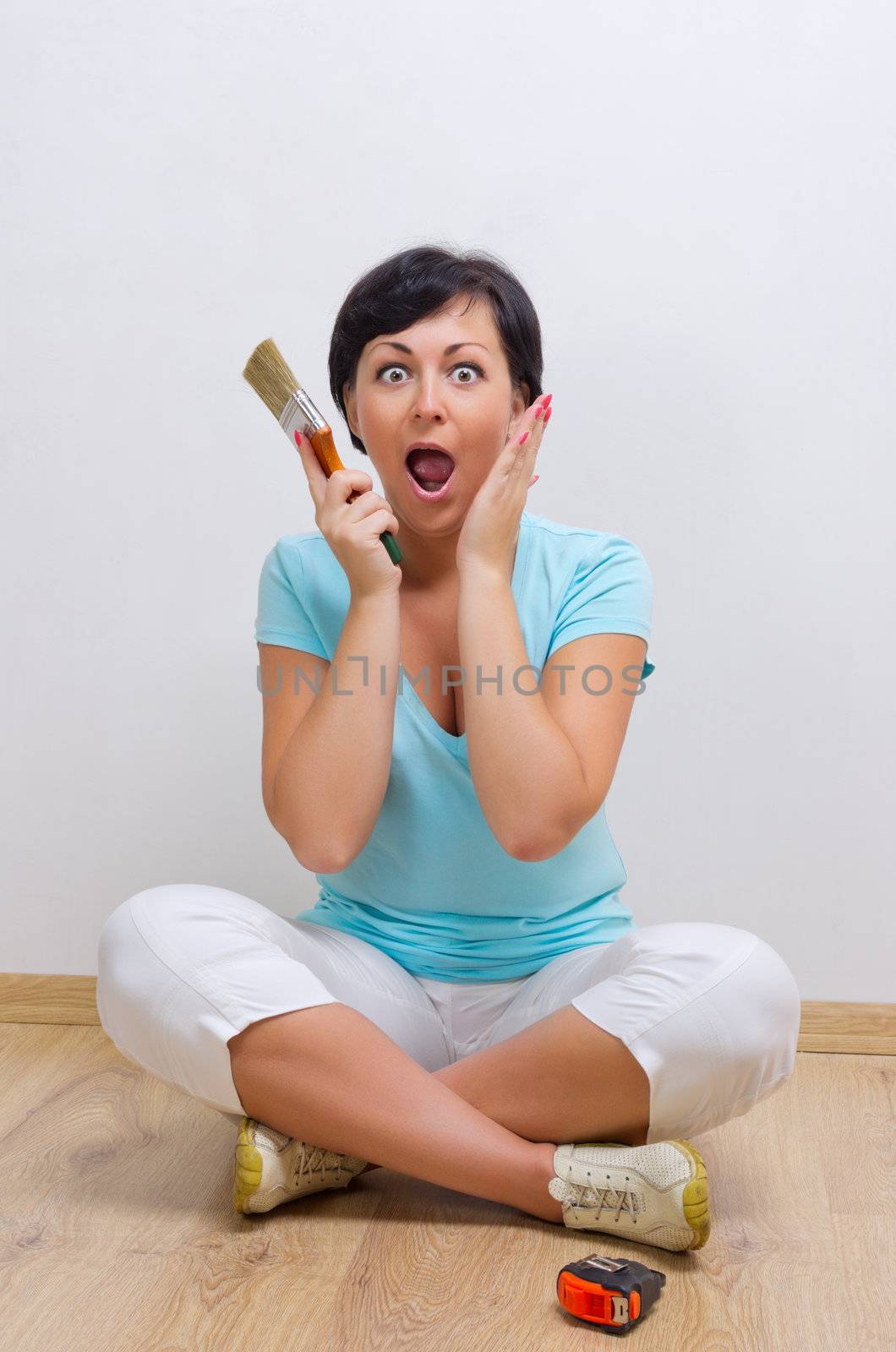 Young surprised woman with painting brush