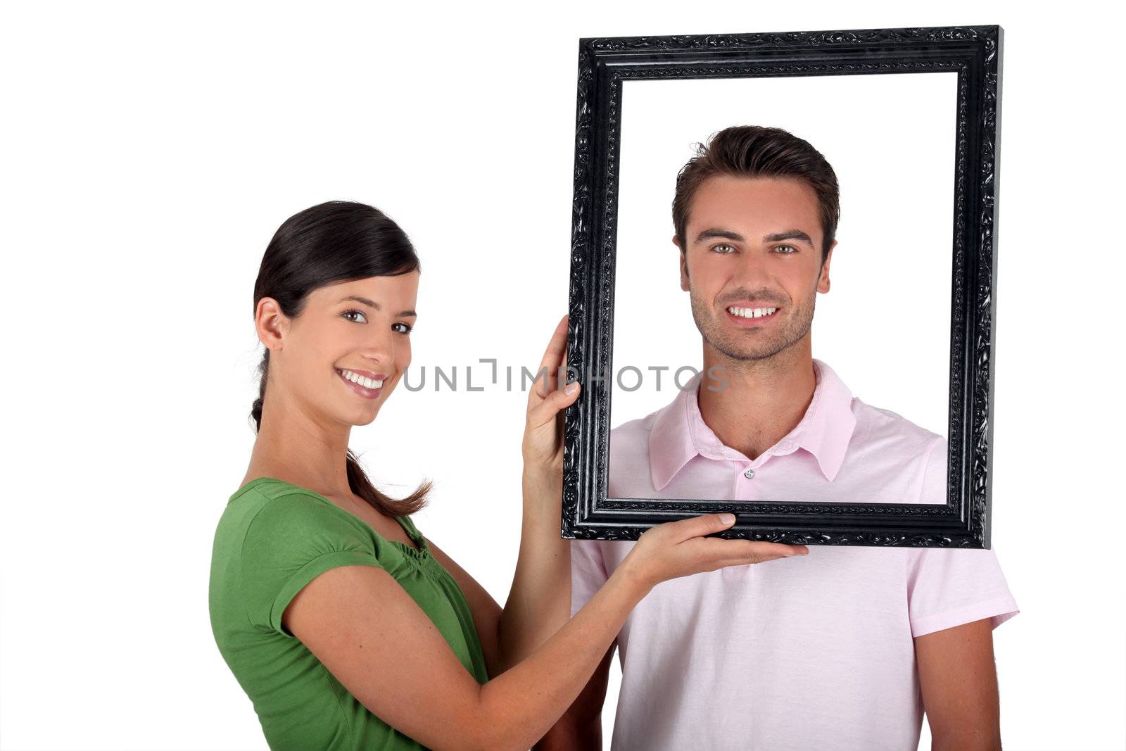Couple holding empty picture frame by phovoir
