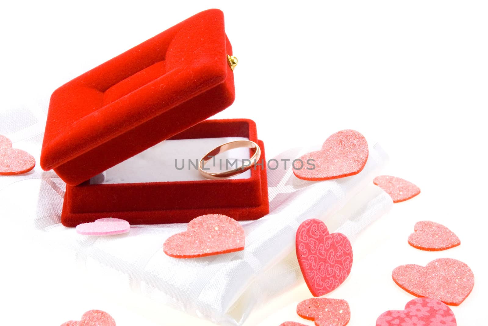 Red gift box with yellow gold wedding ring on white background