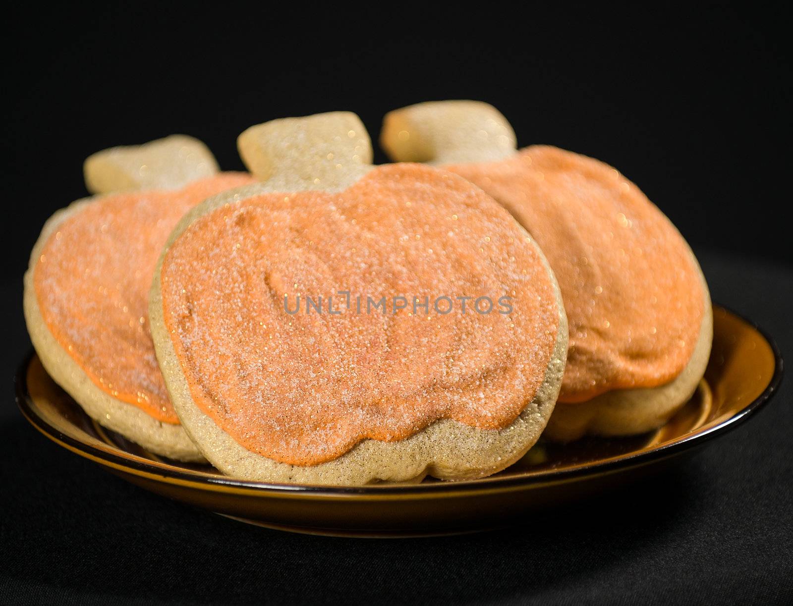 Homemade pumkin cookies on isolated black background.