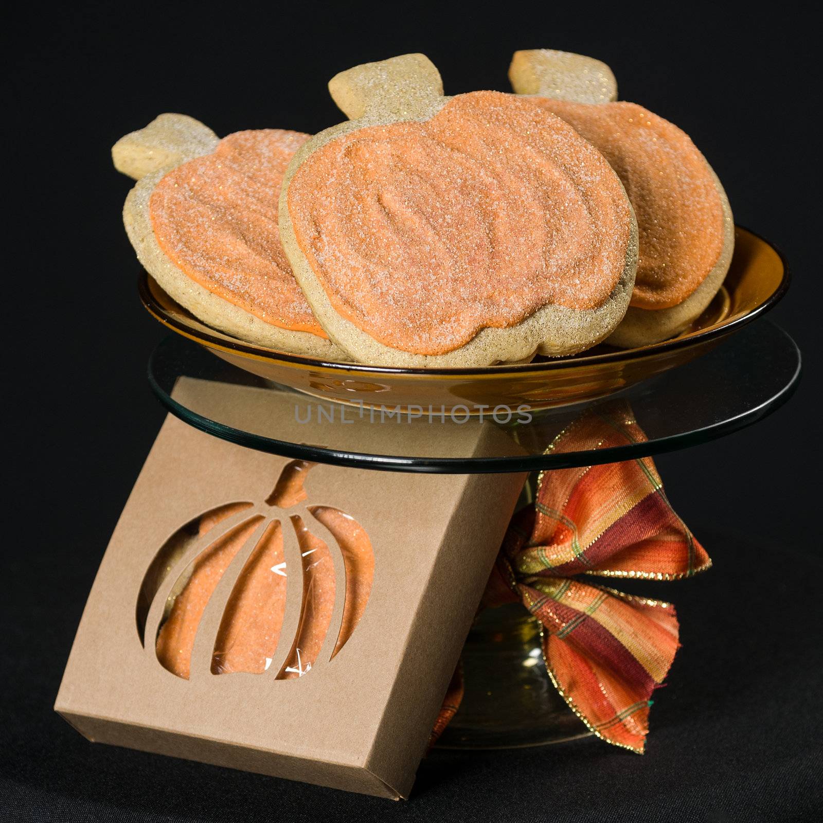 Homemade pumkin cookies on isolated black background.