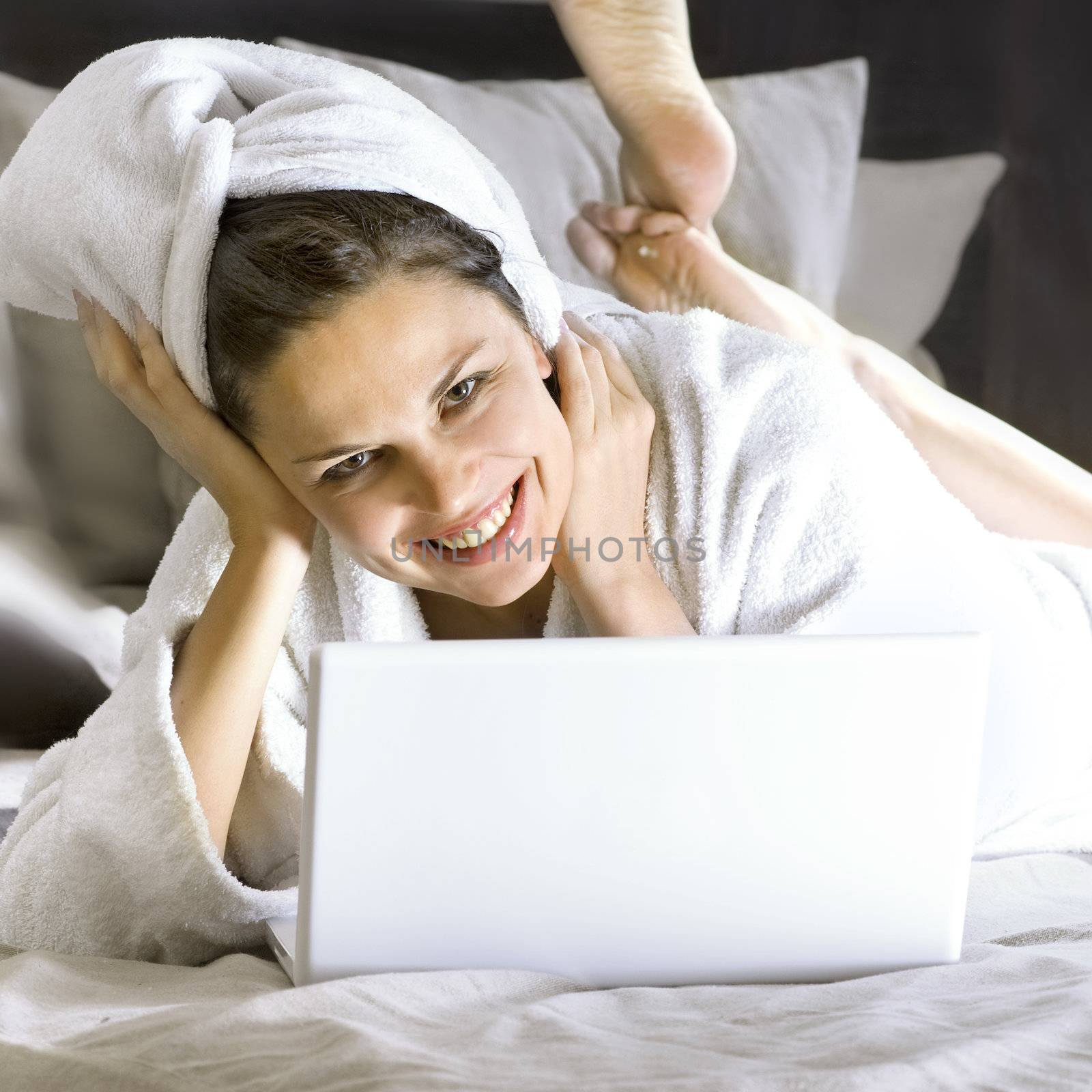 happy woman on the bed with laptop by ssuaphoto