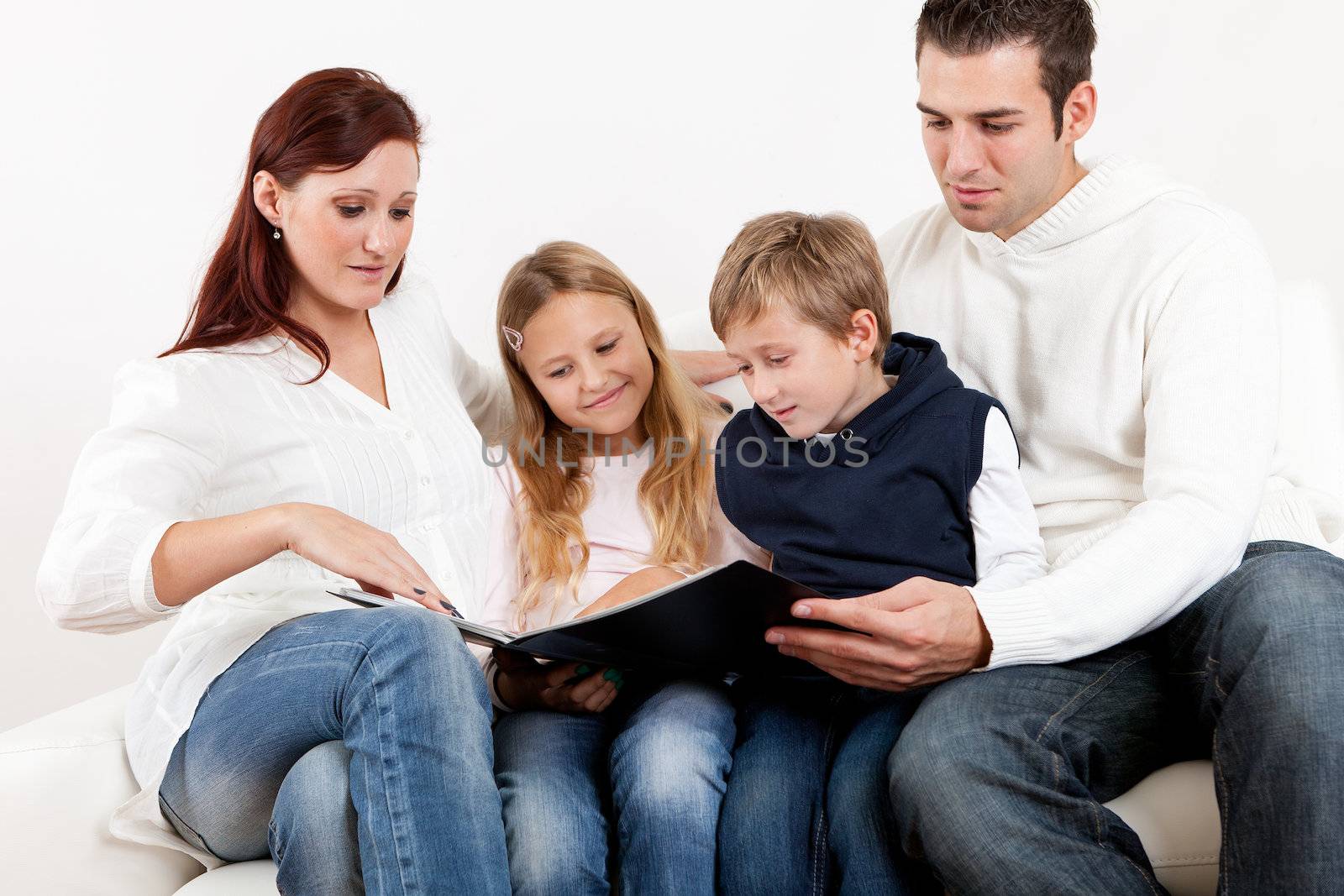 Hapy young family watching photo album at home