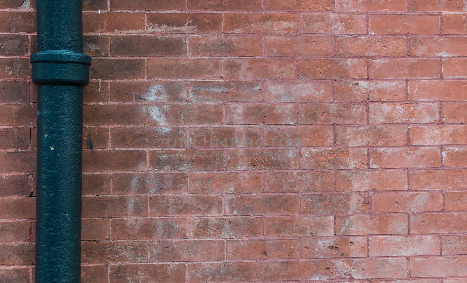 Red rough brick wall with steel pipe background