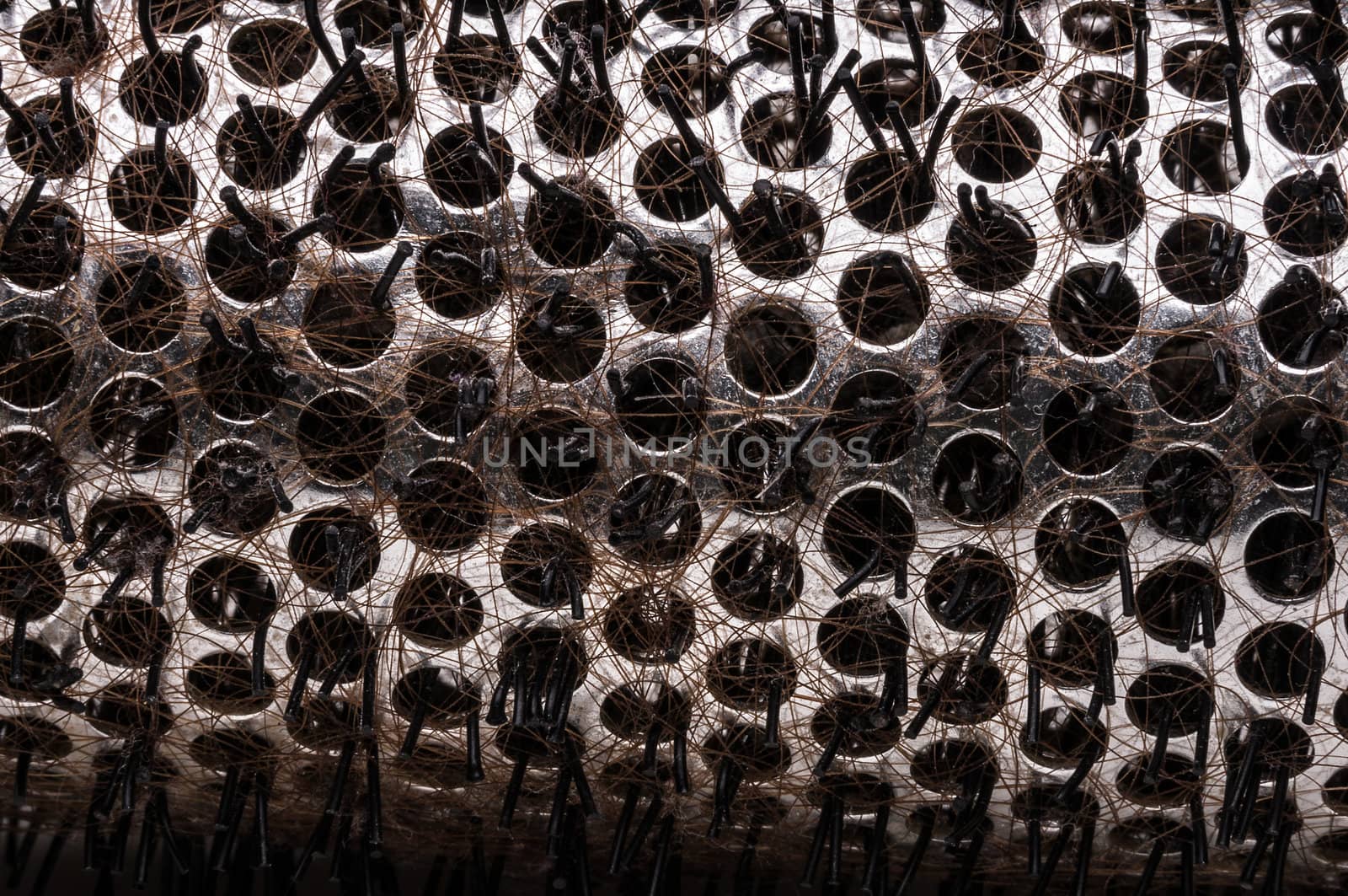 Close up macro shot of hairy hairbrush with brown hair.