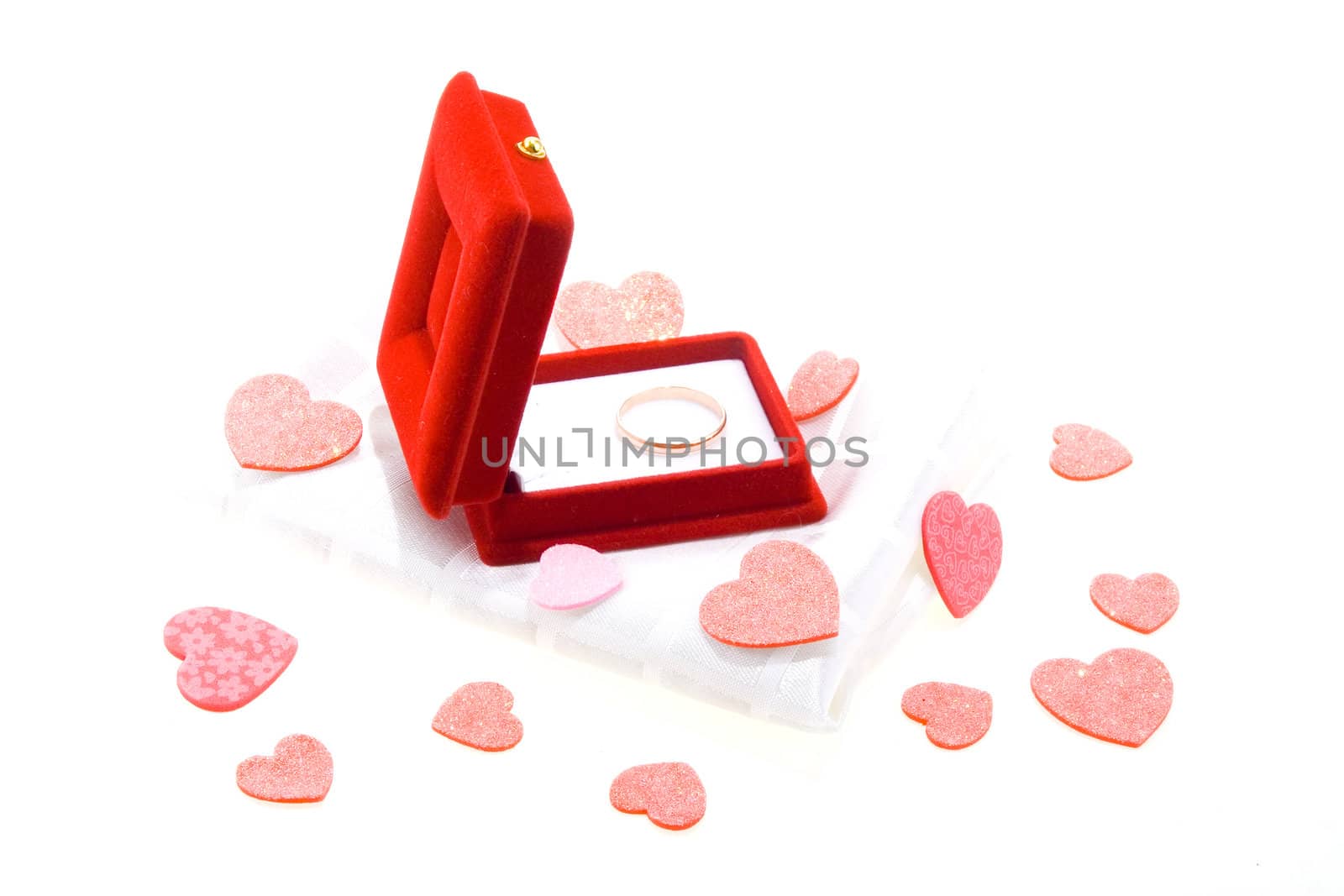 Red gift box with yellow gold wedding ring on white background