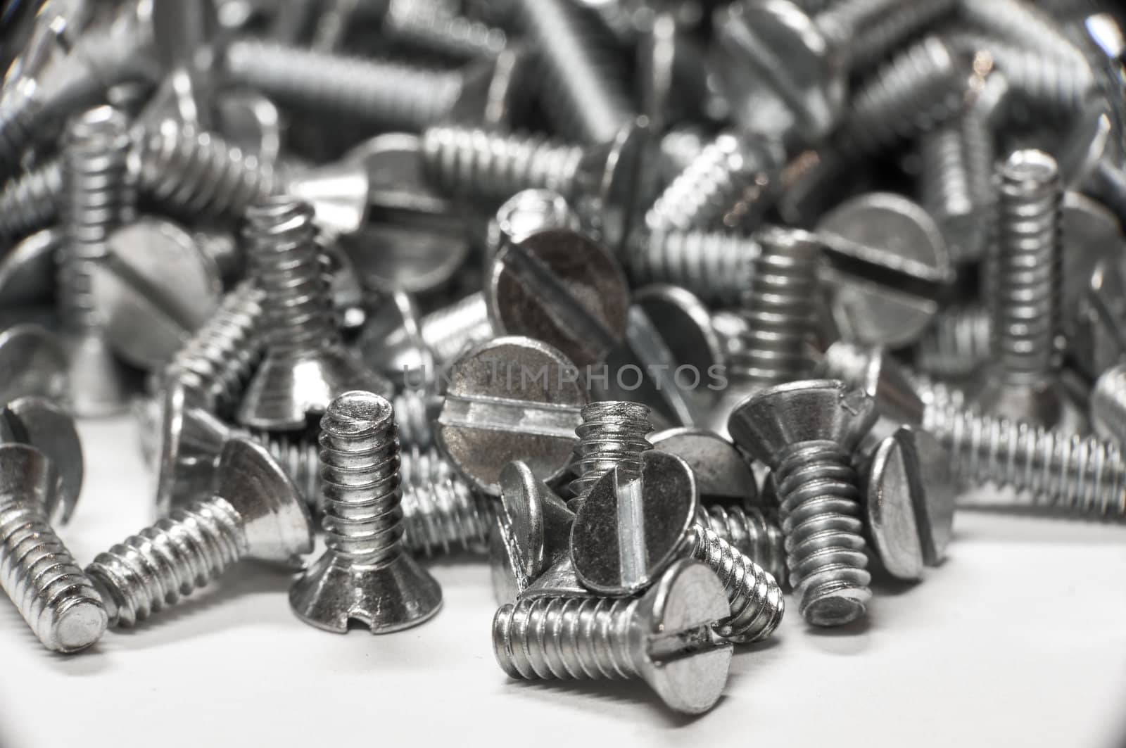 Macro shot of screws on white paper