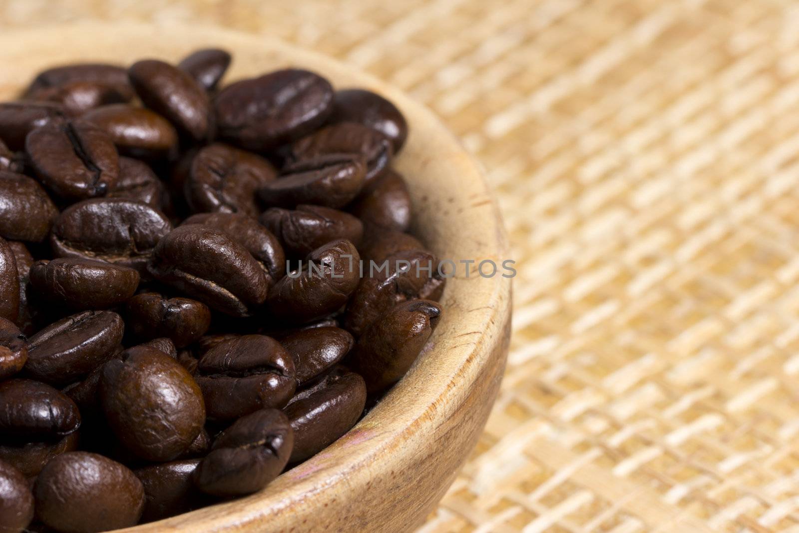 Fresh roasted coffee beans on light textured surface