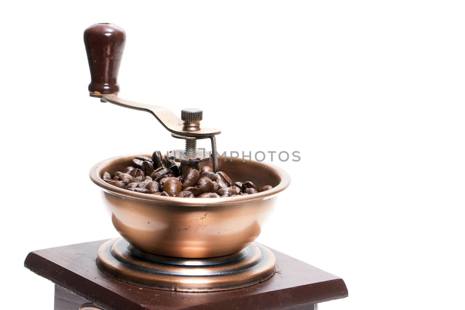 Fresh roasted coffee beans in the manual coffee grinder on white background