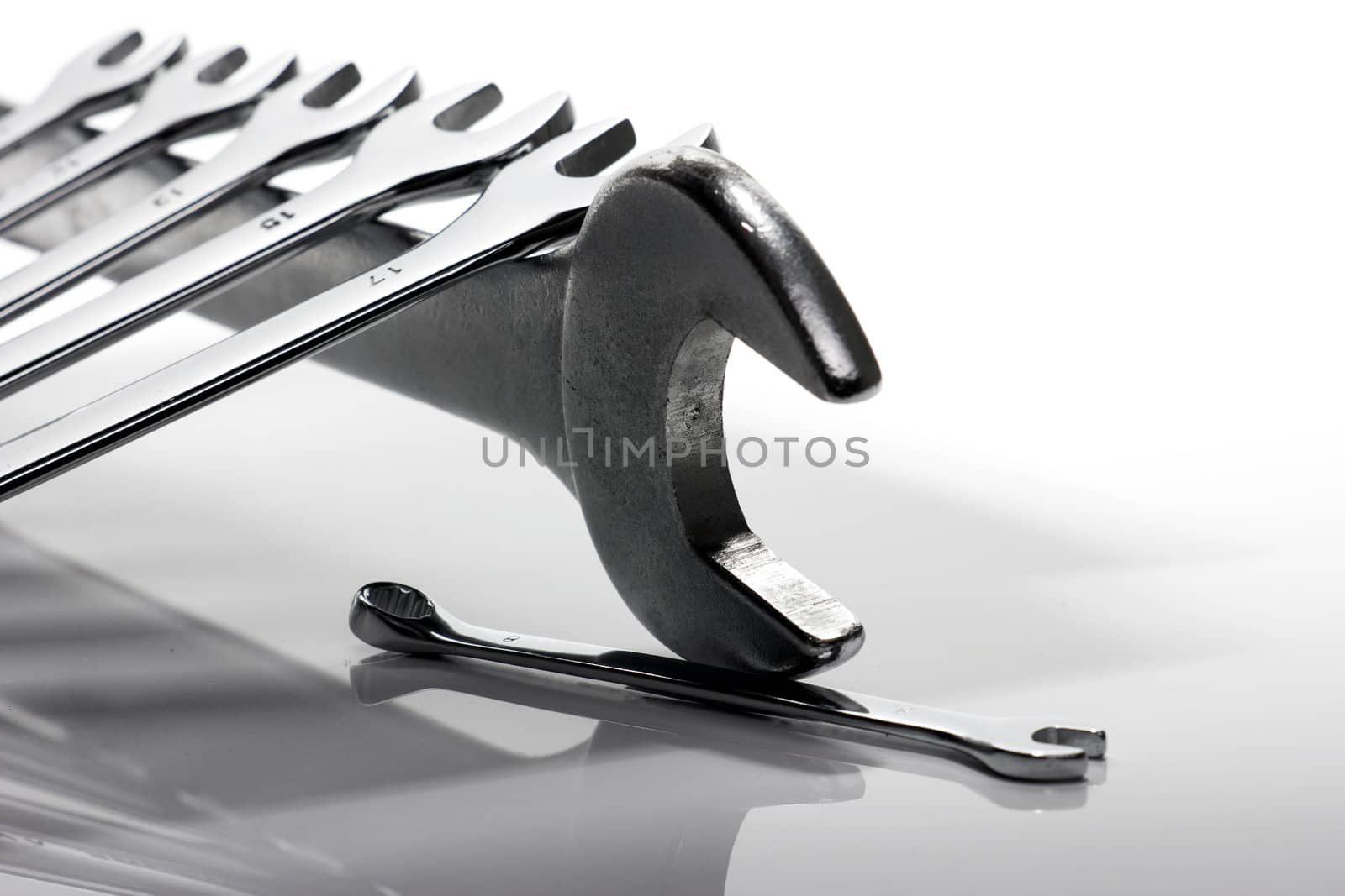 Some steel wrenches of different sizes on a white background