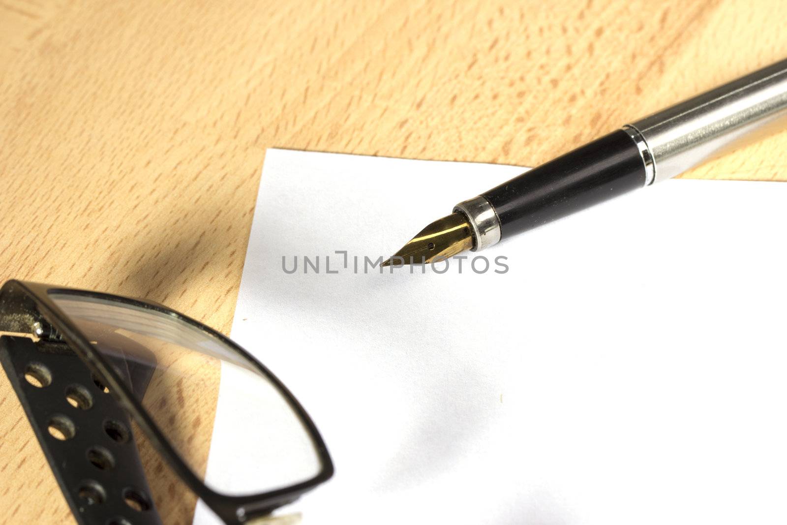 A sheet of white paper and fountain pen with gold nib at the work desk