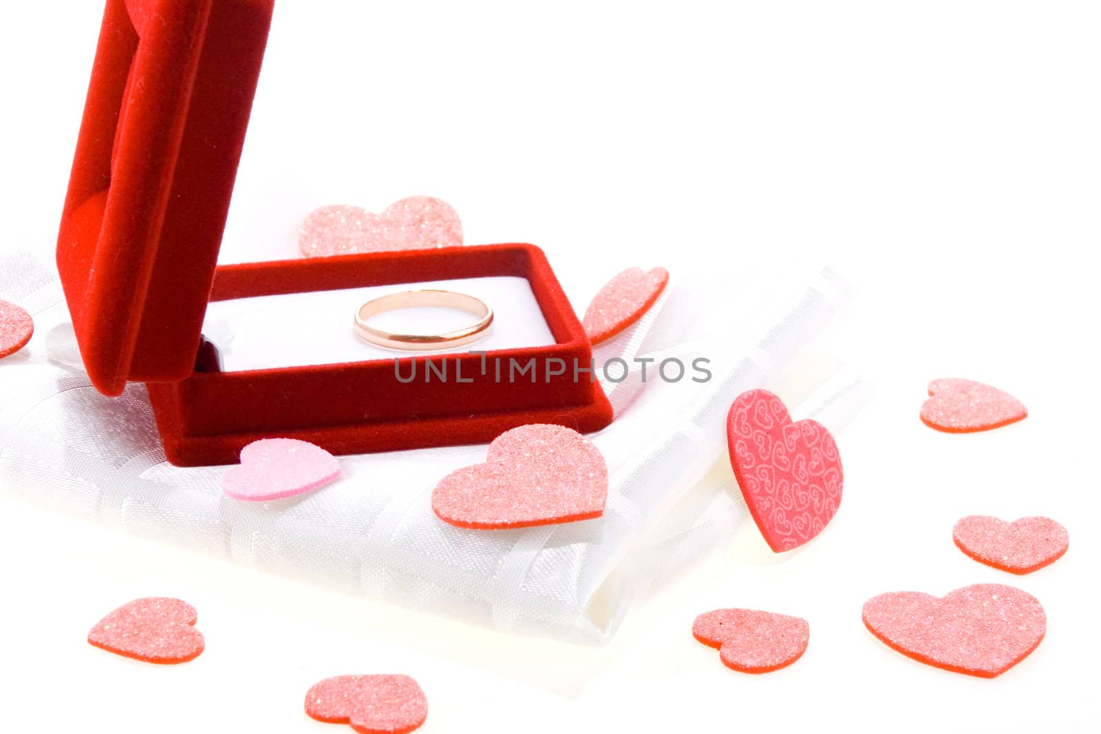 Red gift box with yellow gold wedding ring on white background