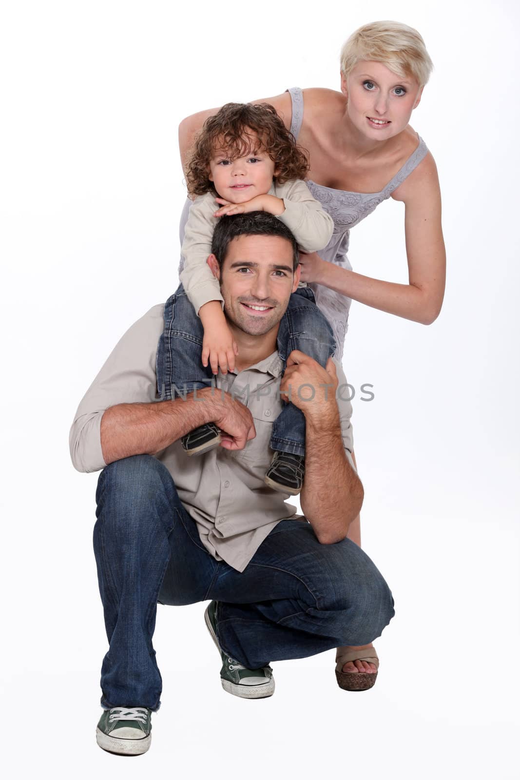 Young family posing in a studio by phovoir